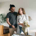 Excited couple unpacking boxes in new apartment
